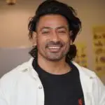 Portrait of a smiling man wearing casual attire indoors, bright and cheerful.